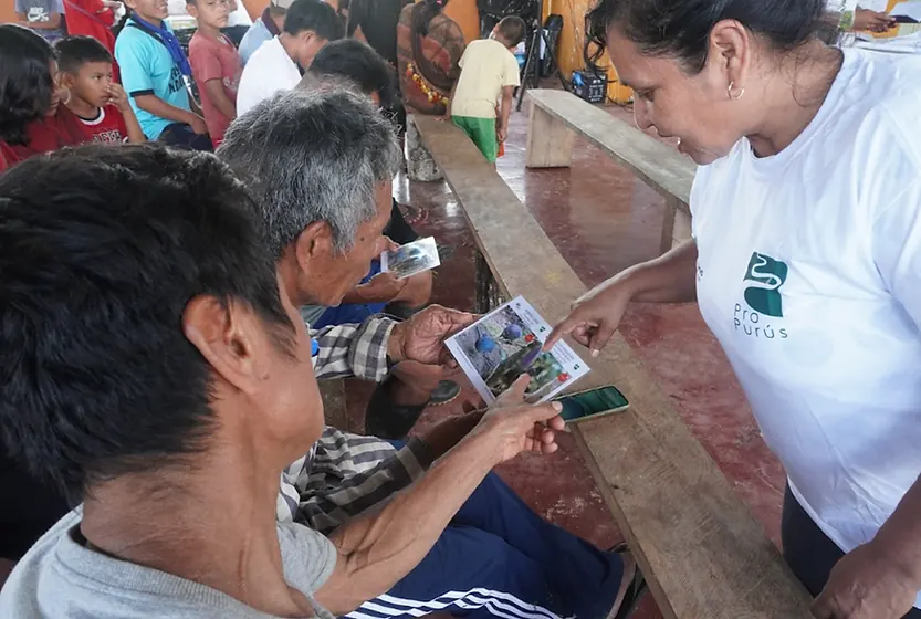 Los comuneros observan el material informativo sobre especies de aves registradas durante el monitoreo de avifauna, prom